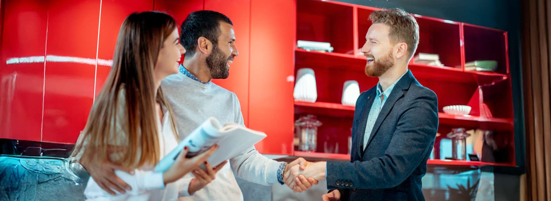 Beratungssituation im Einrichtungshaus mit Küchenverkäufer und Paar