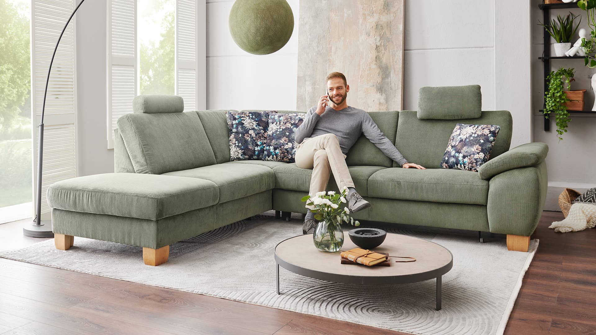 gemuetliches ecksofa mit gruenem cordbezug holzfuessen und verstellbaren kopfstuetzen