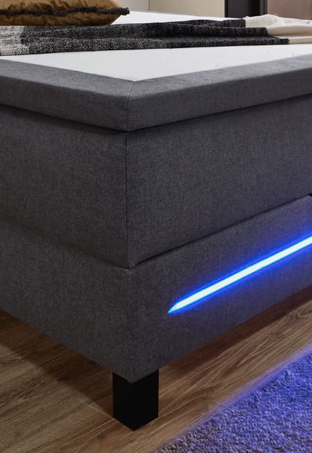 polsterbett mit grauem stoffbezug und integrierter led beleuchtung